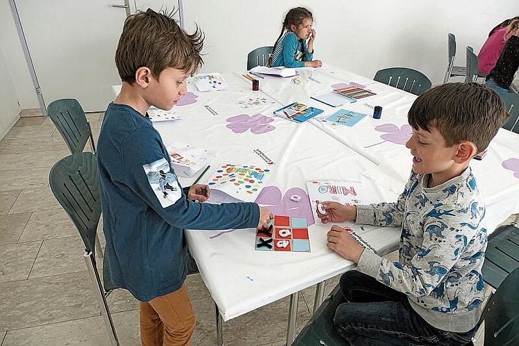 Dario und Miro spielen vergnügt mit dem selbst gebastelten Tic-Tac- Toe.