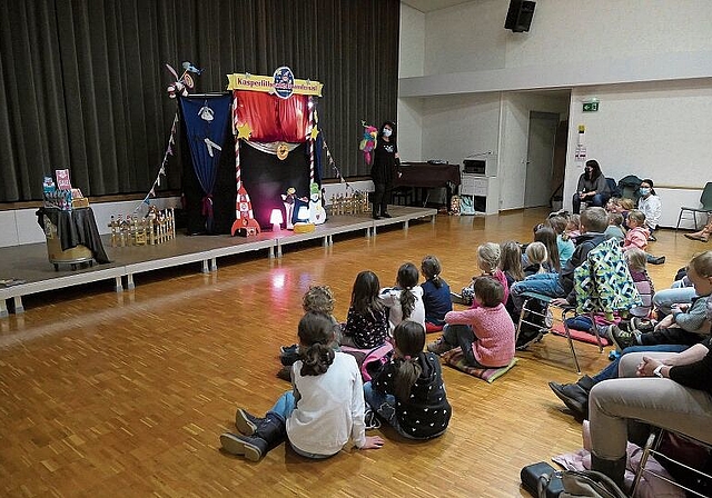 Die Puppenspielerin Manuela Steiner begrüsst mit Papagei Karli die Kleinen und Grossen und die Organisatorin Irène Persson (sitzend an der Wand).