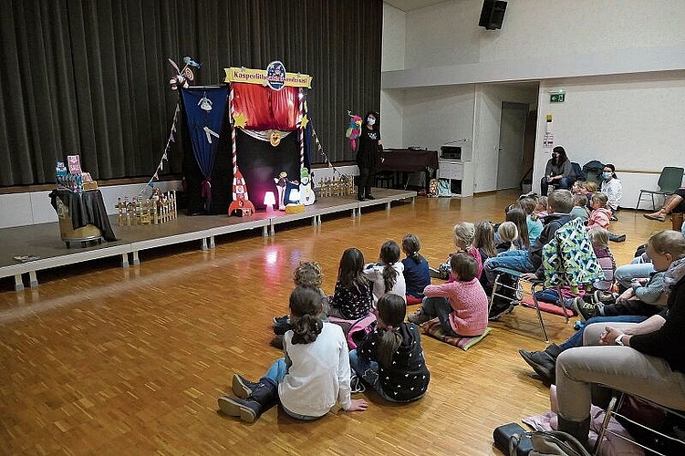 Die Puppenspielerin Manuela Steiner begrüsst mit Papagei Karli die Kleinen und Grossen und die Organisatorin Irène Persson (sitzend an der Wand).