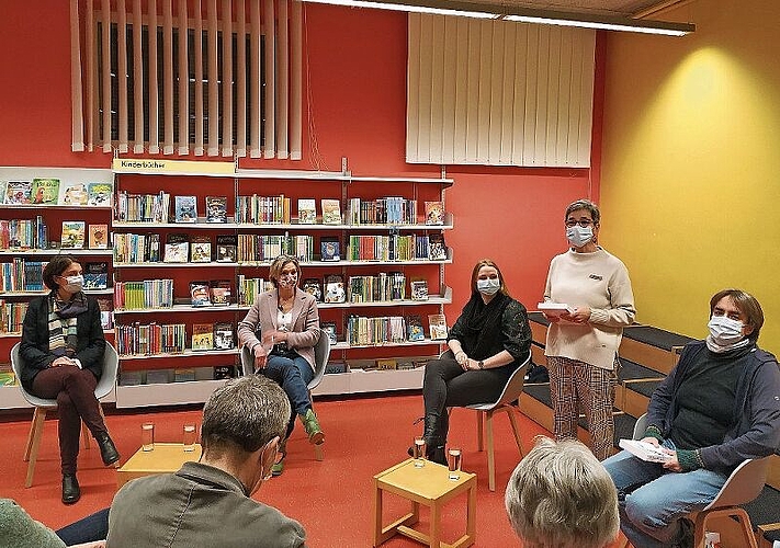 Leiterin der Gemeindebibliothek, Jacqueline Eggenschwiler (stehend), heisst die drei Politikerinnen zur Veranstaltung willkommen.