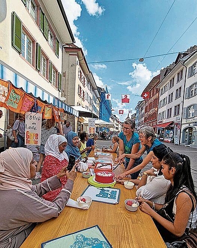 Kathy Gallo und Silvia Bolliger schneiden die Geburtstagstorte an.
